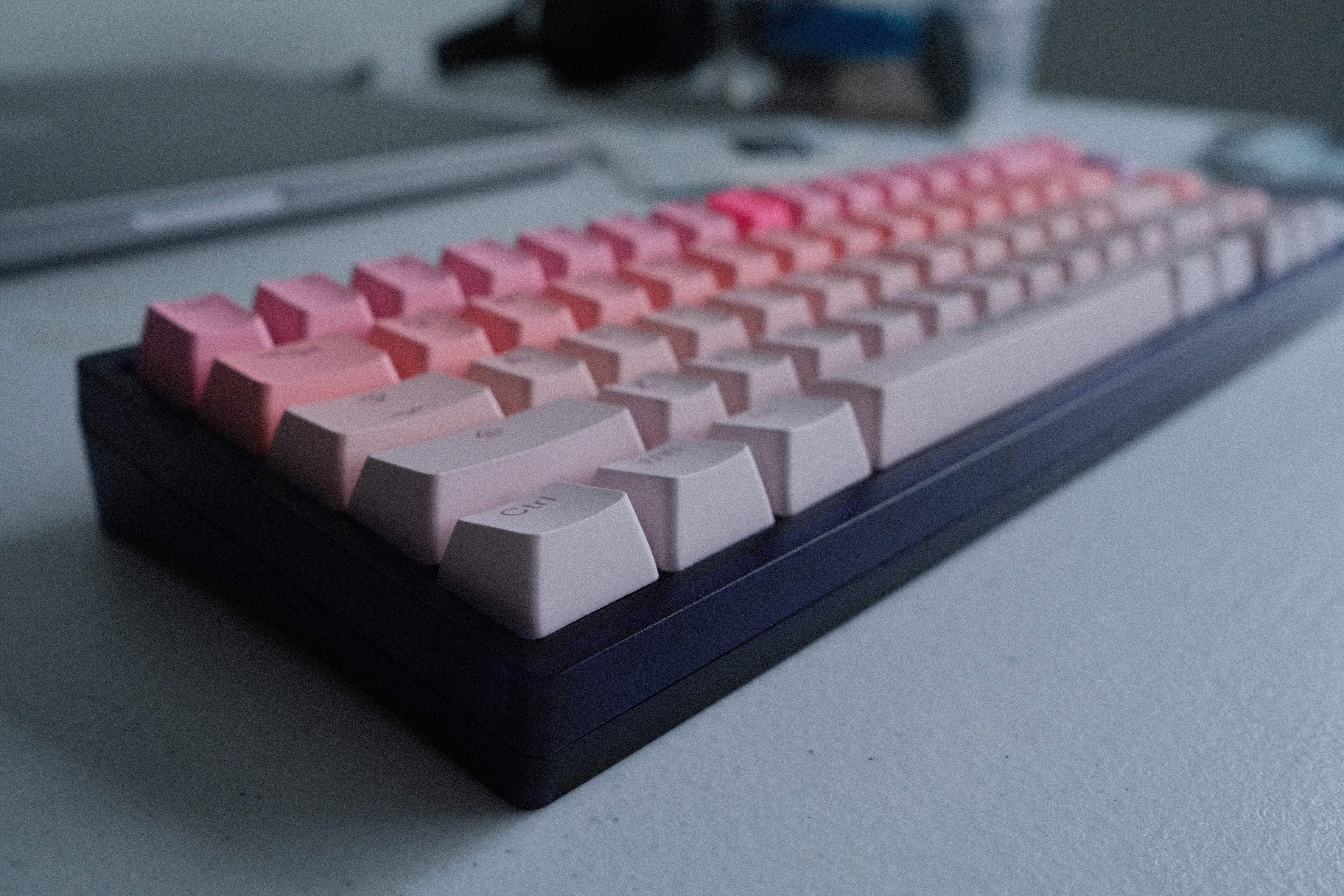side view of a purple keyboard case with keycaps that run from vivid to pale pink and orange