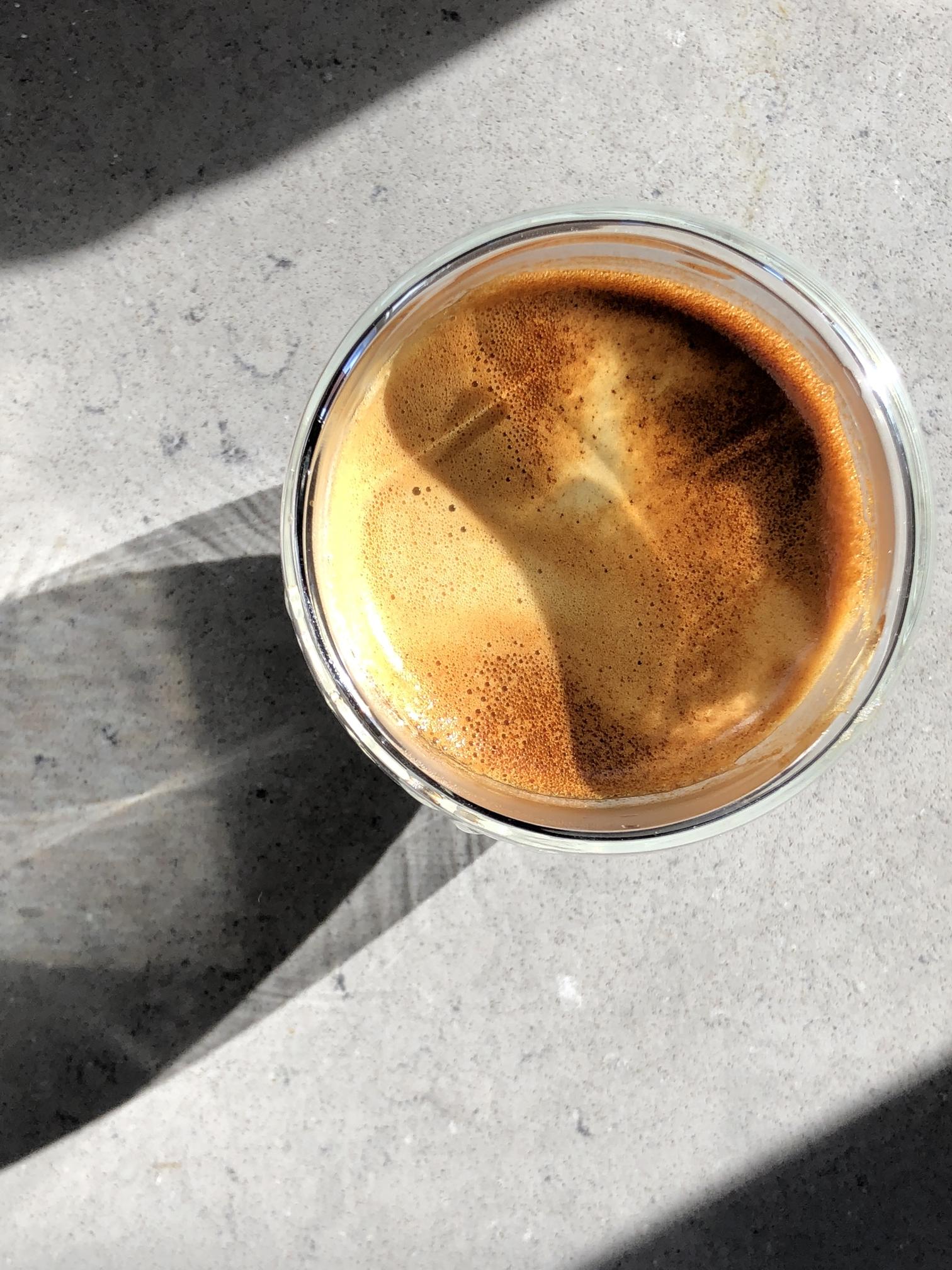 espresso cup from above, bright gold colored in the sun 