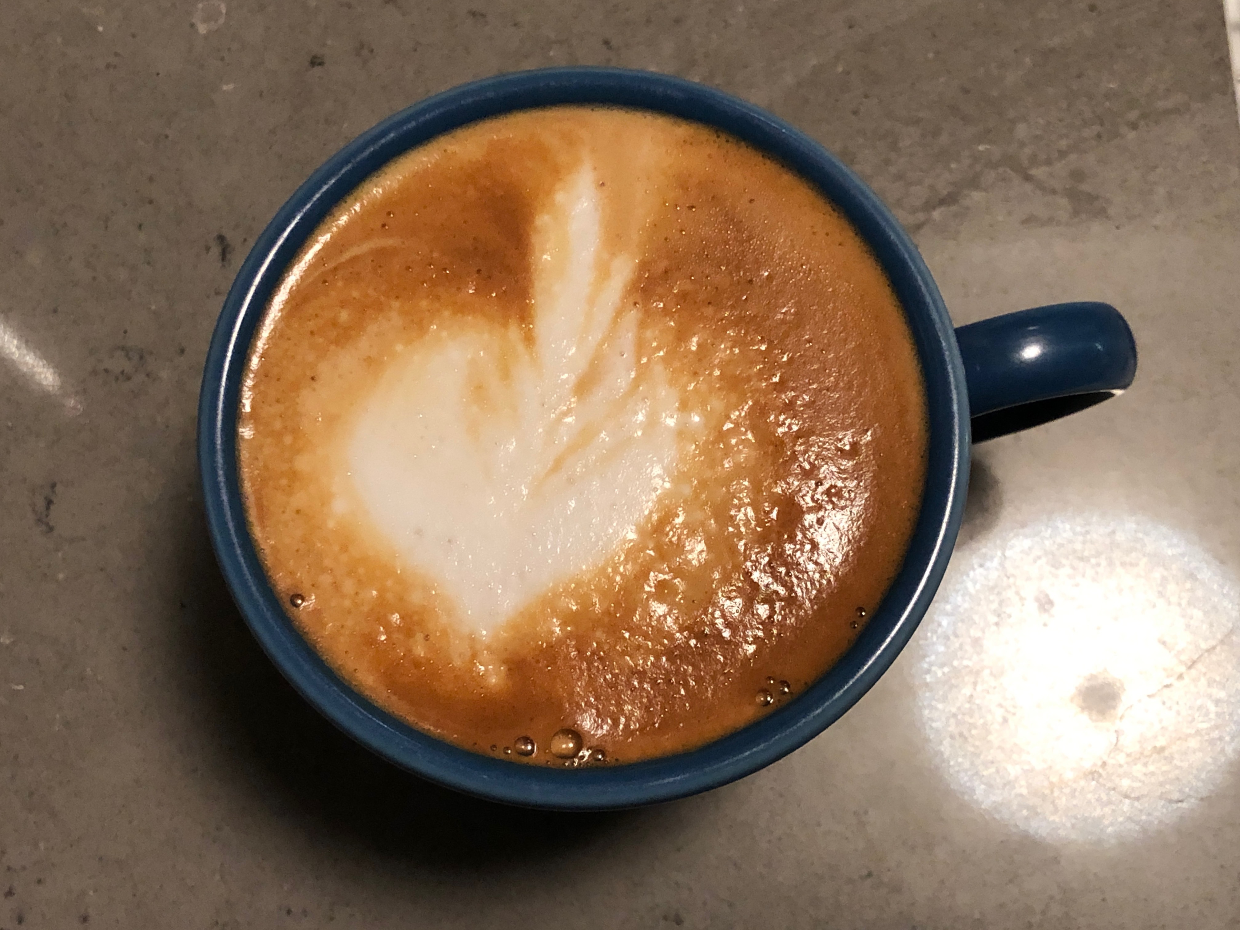 Photo of a cappuccino in a blue mug 