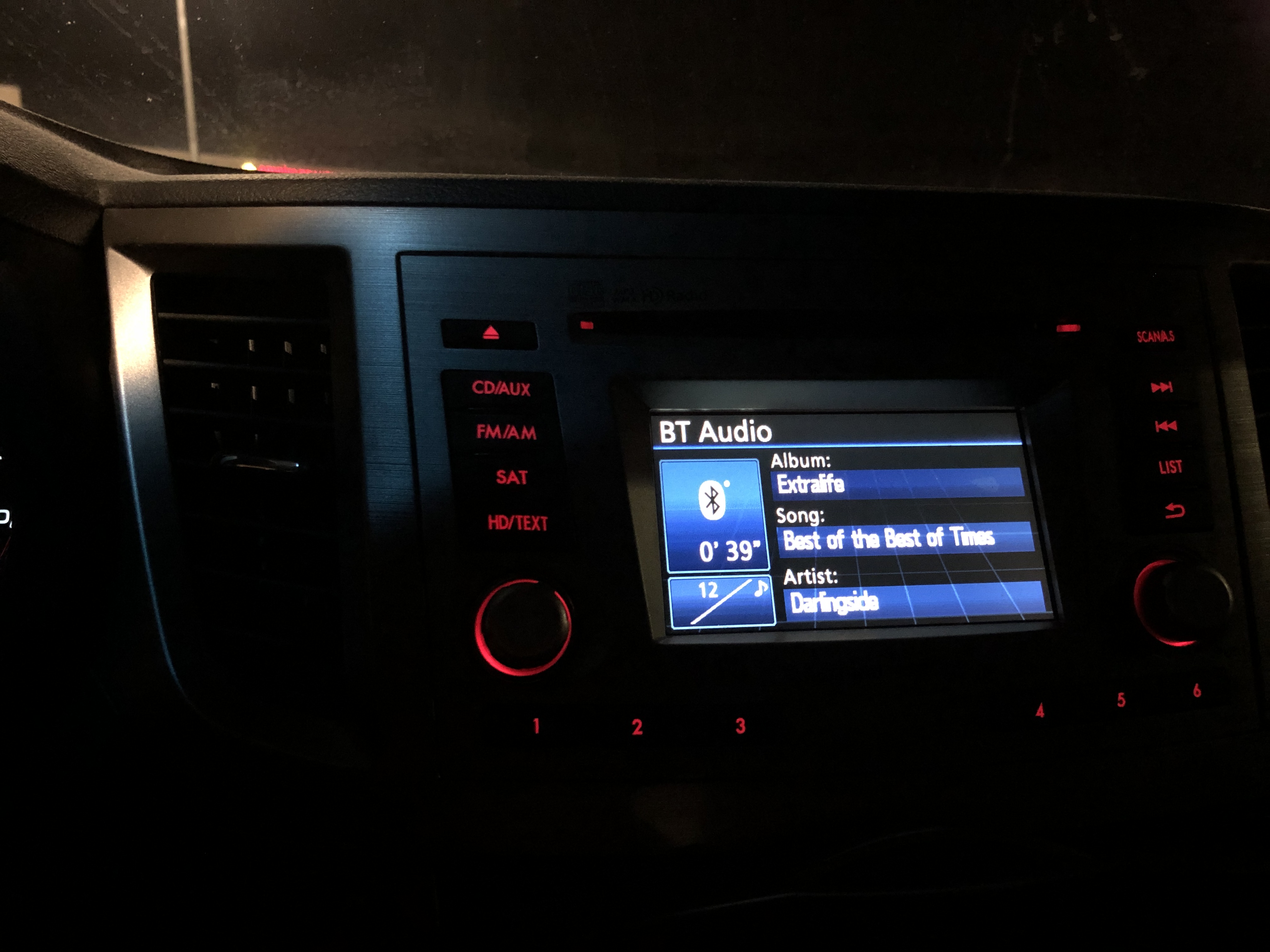 Nighttime dashboard showing Best of the Best of Times by Darlingside playing on the stereo 