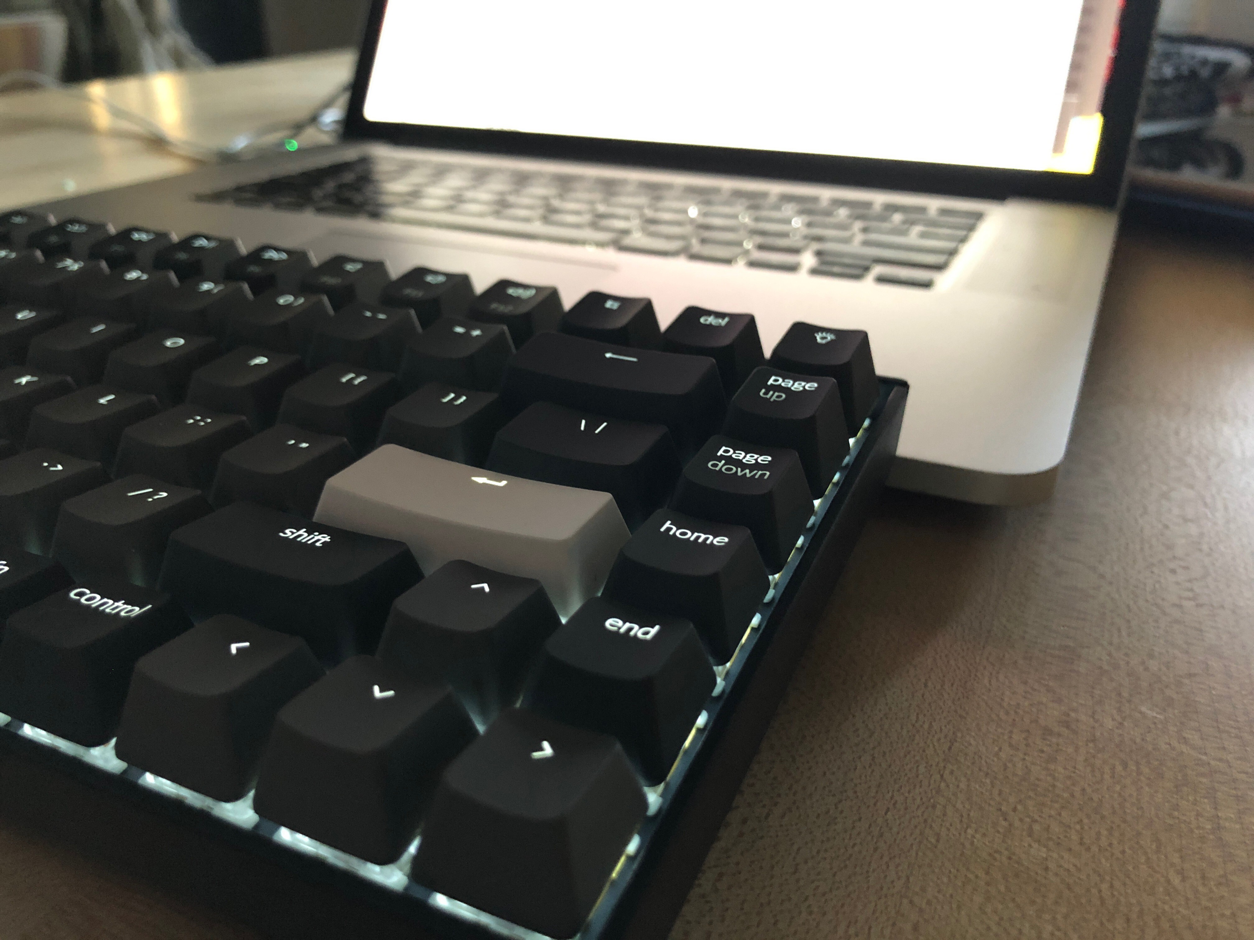 a mechanical keyboard with dark gray keys and a white backlight 