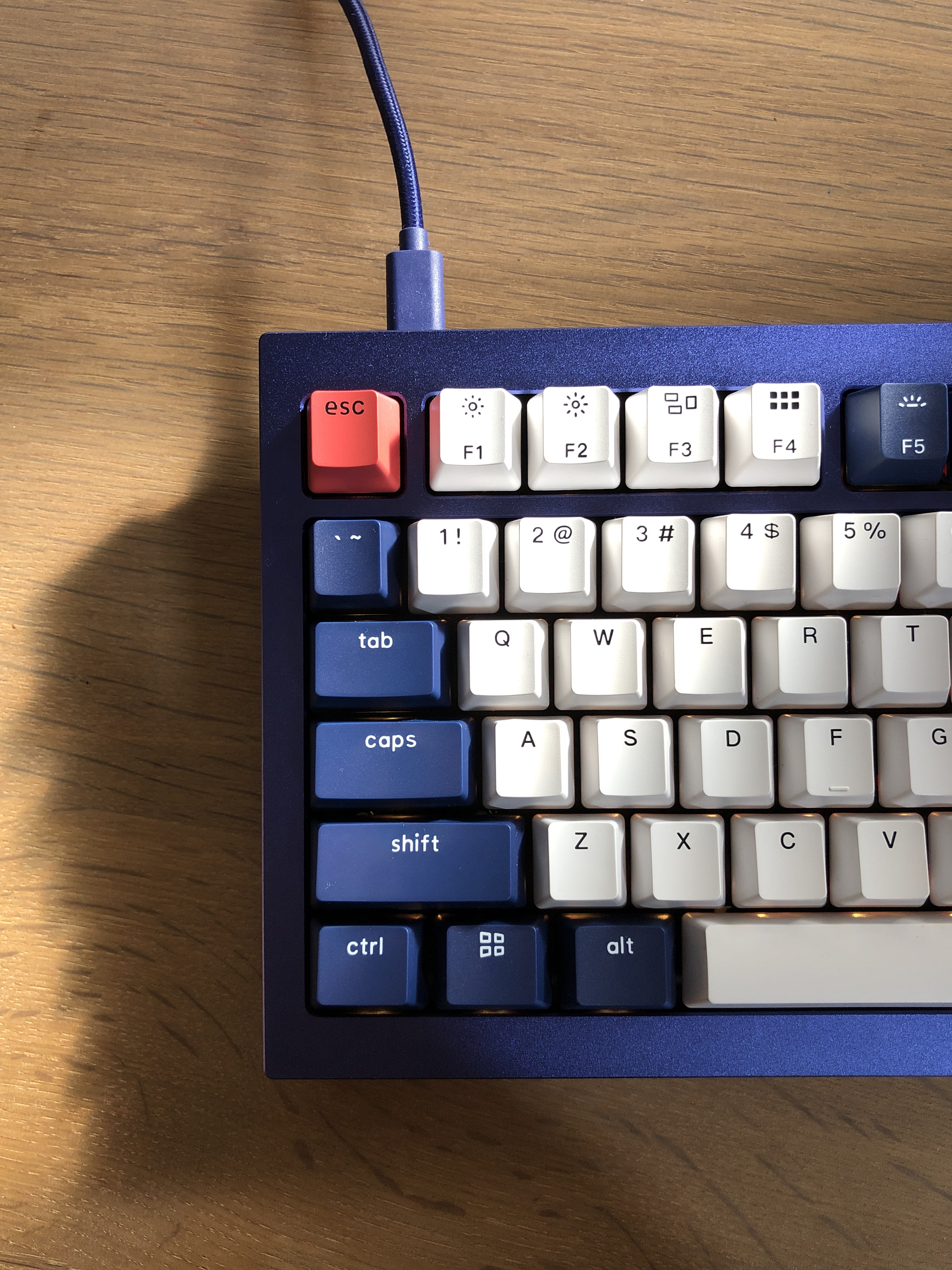 Photo of a mechanical keyboard with a slightly shimmery blue case, and blue and white keys.  
