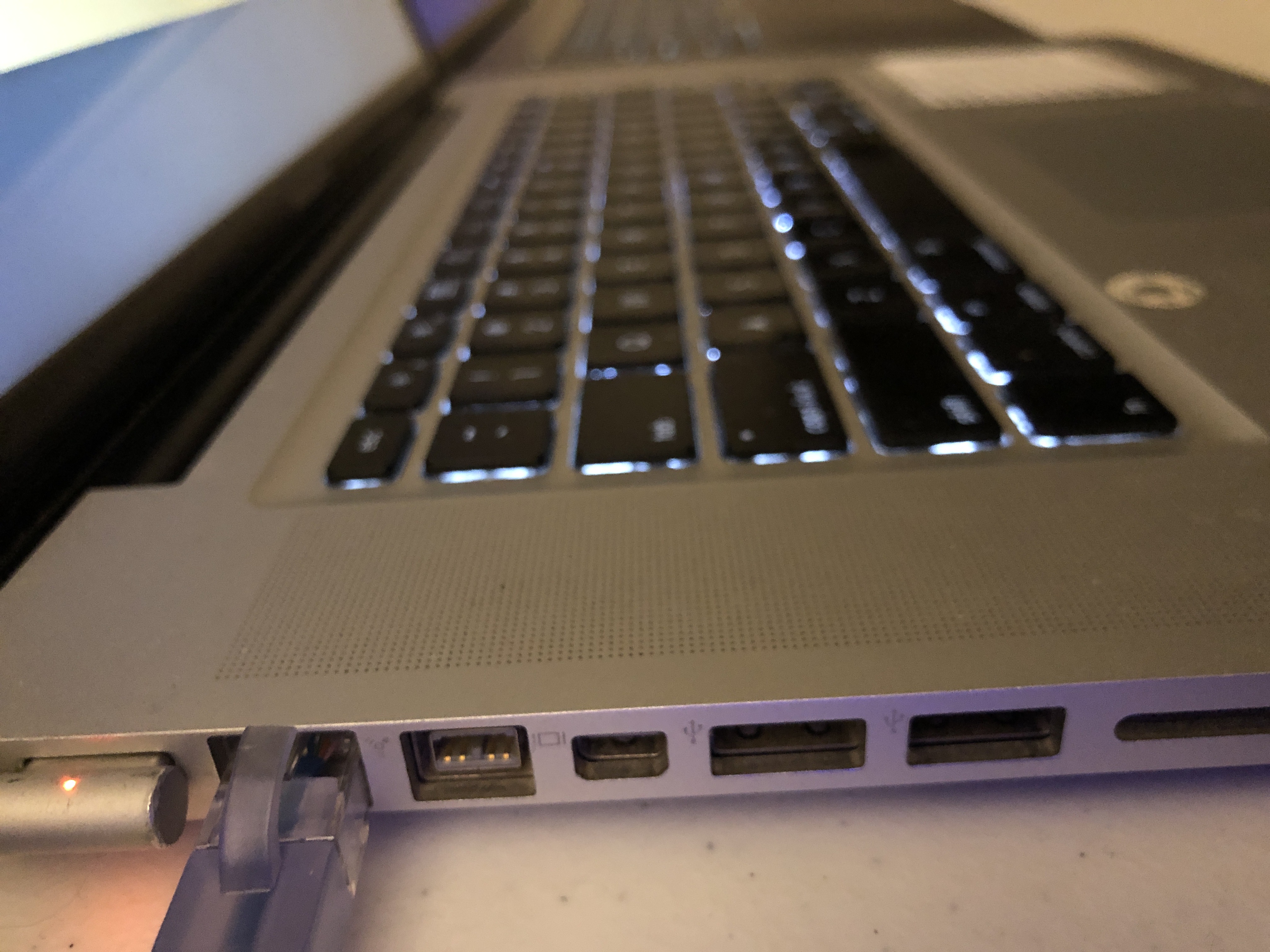 A side view of an old MacBook, showing ethernet, MagSafe, USB, SD card, DisplayPort and Thunderbolt ports. 